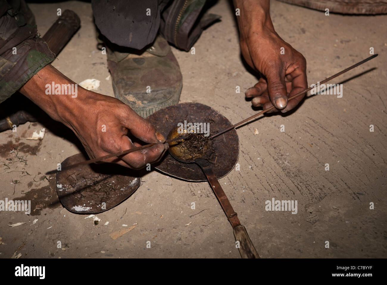 India, Nagaland, Longwa, mani di Konyak Naga uomo miscelazione oppio fuso con il tabacco Foto Stock