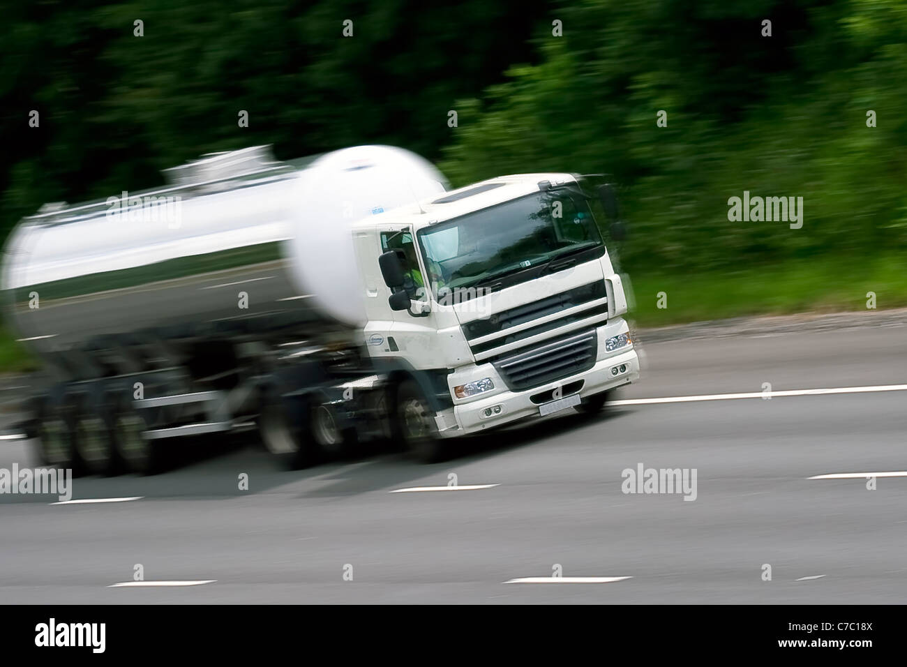 Un autocarro cisterna che viaggia sull'autostrada M4 nel Galles del Sud, mostrando il movimento della logistica dei trasporti in un ambiente stradale affollato. Foto Stock