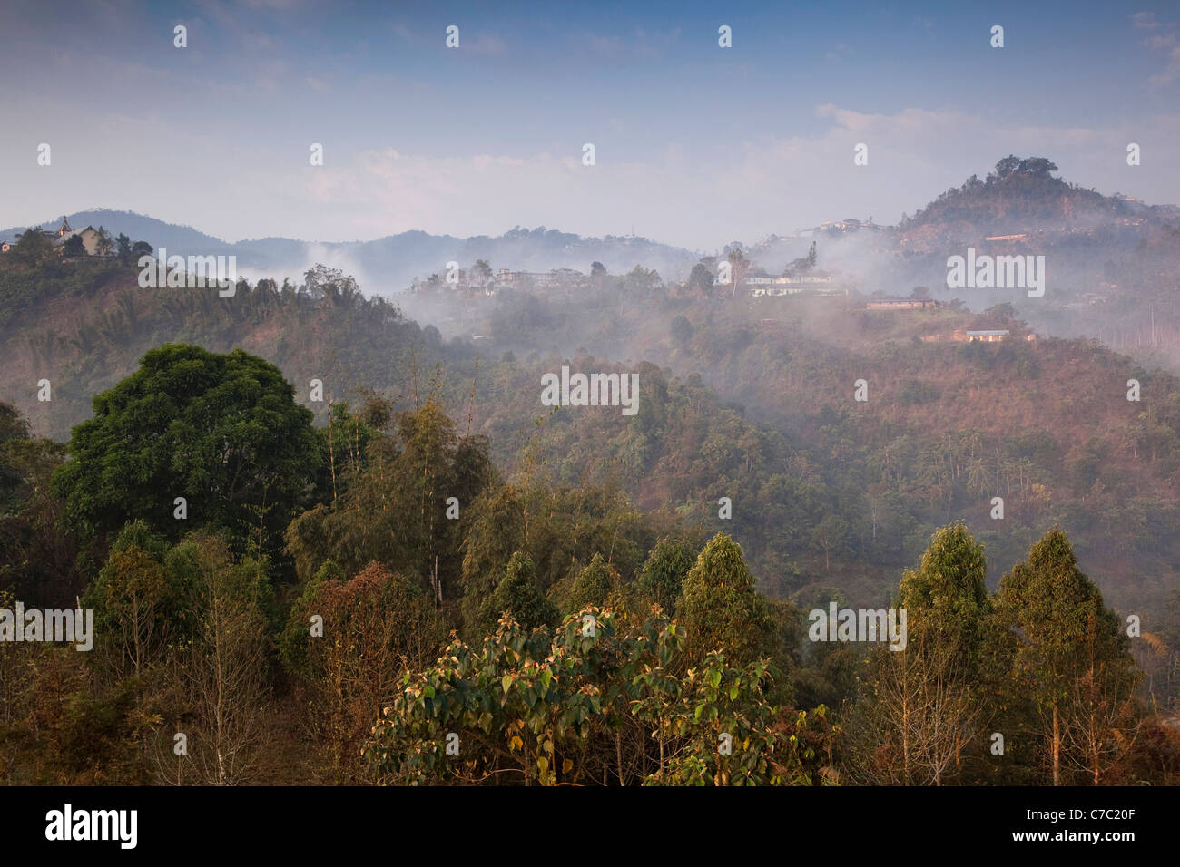 India, Nagaland, uomo, early morning mist su case di collina Foto Stock