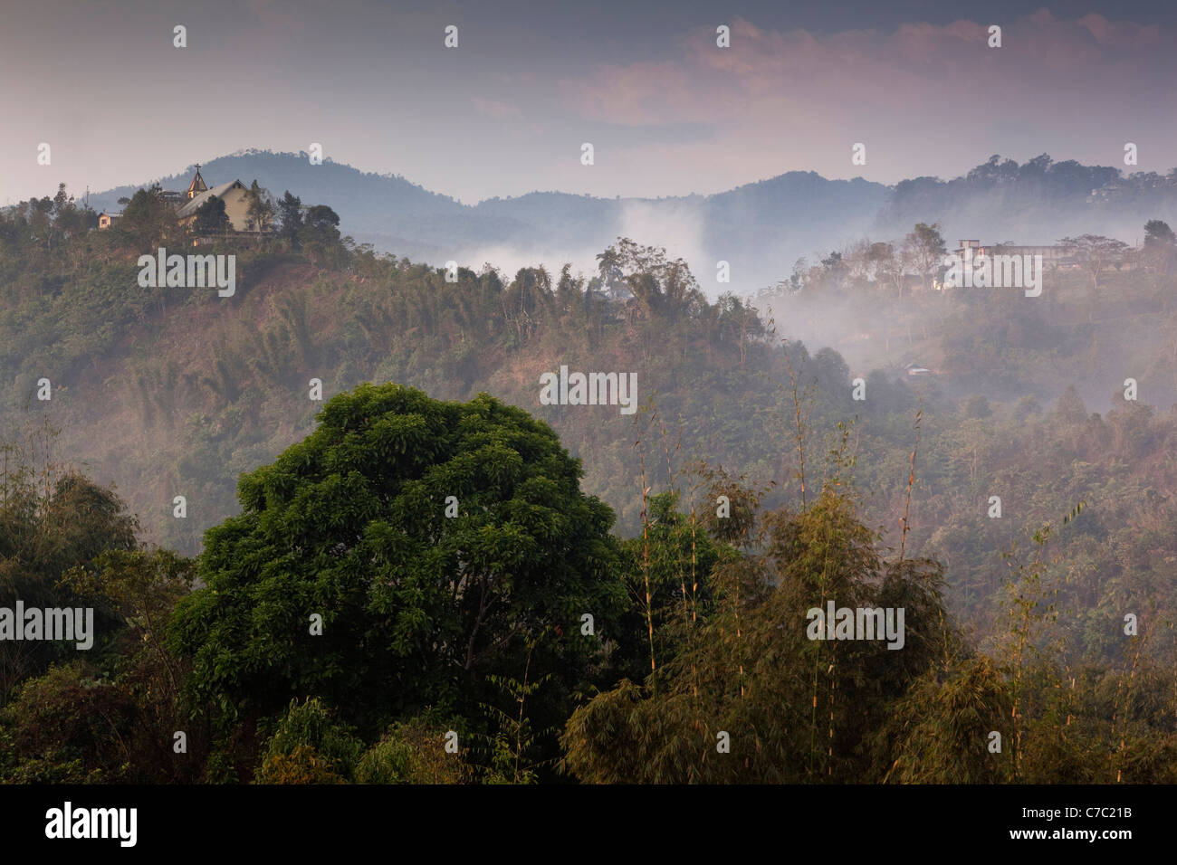 India, Nagaland, uomo, early morning mist su case di collina Foto Stock