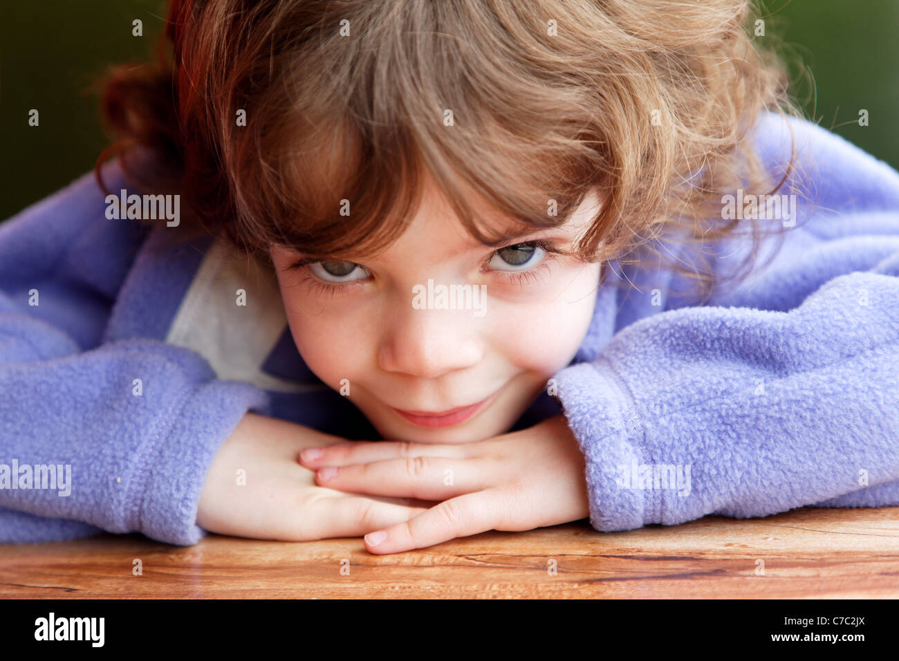 Bambina di cinque anni mento di appoggio sul tavolo Foto Stock