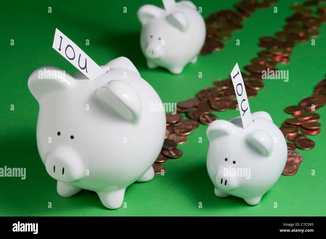 Salvadanaio con IOU che esce di coin slot e il denaro proveniente da piggy banche Foto Stock