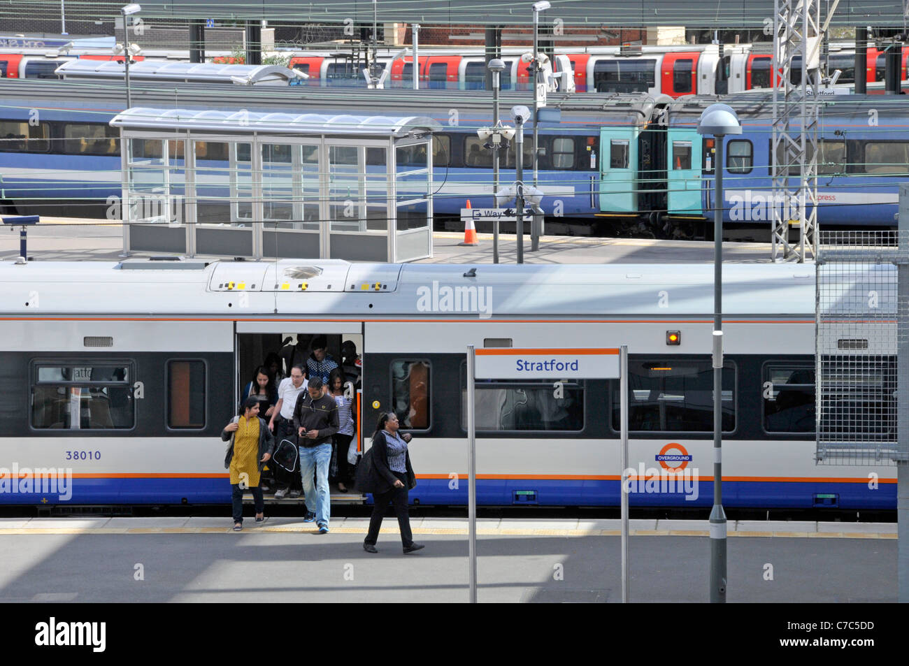 I mezzi di trasporto pubblici vista dall'alto guardando verso il basso sulla Stratford London stazione ferroviaria pendolari che arrivano in corrispondenza della piattaforma dal treno Overground England Regno Unito Foto Stock