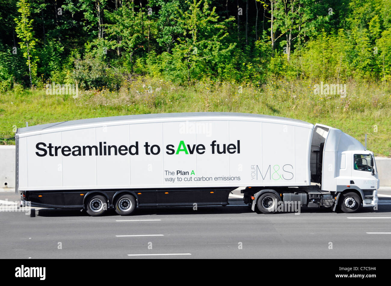 Distribuzione semplificata della catena di fornitura articolata M&S autocarro conducente e lato del rimorchio pubblicità carburante e emissioni di carbonio piano di risparmio di UN'autostrada del Regno Unito Foto Stock