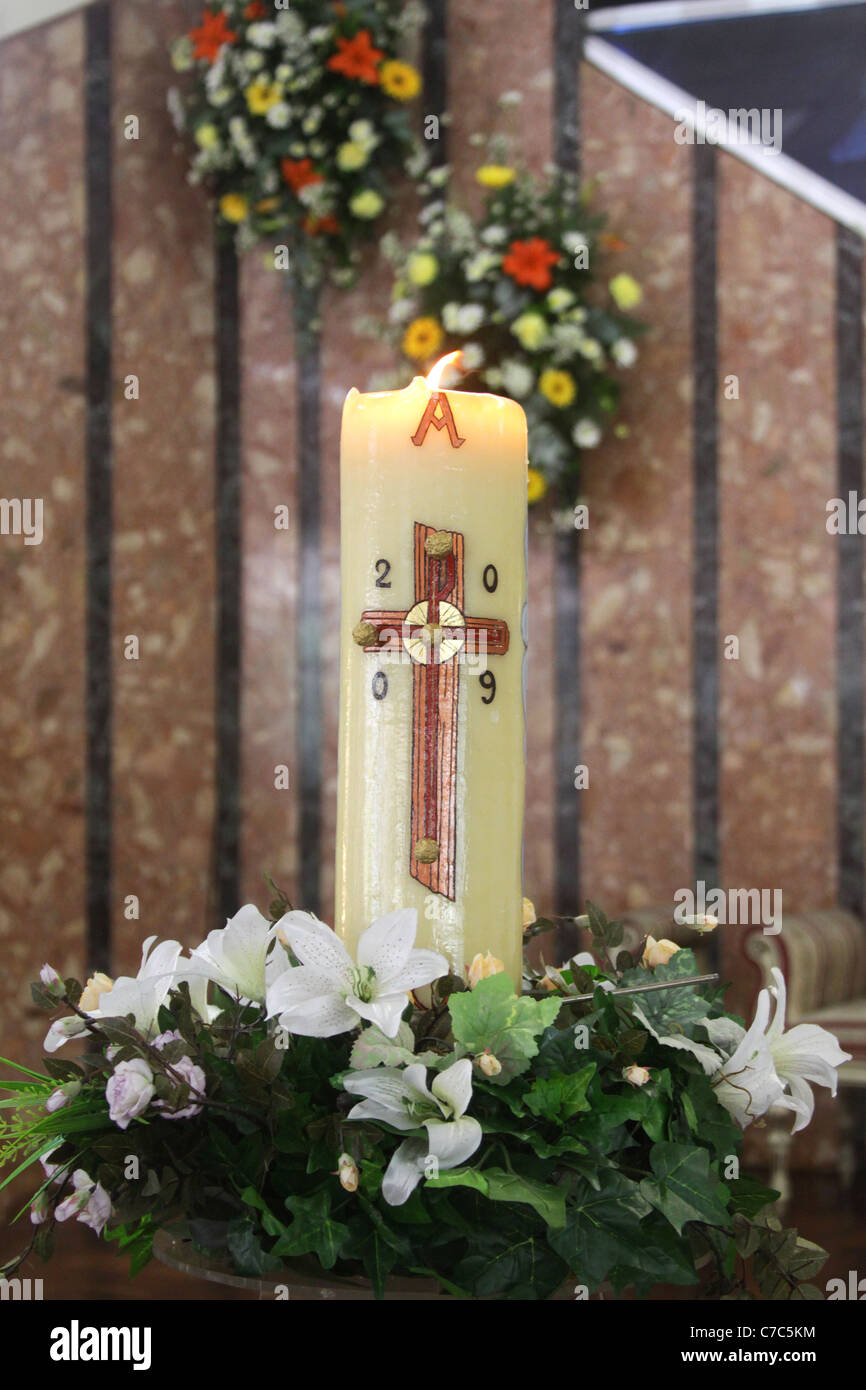 Cero pasquale, illuminata e decorata con fiori. Foto Stock