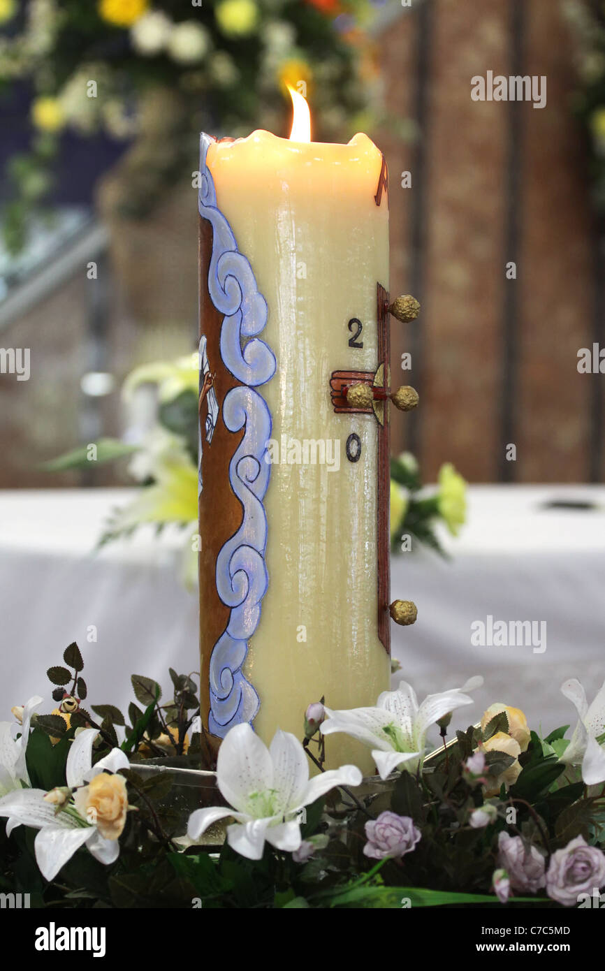 Cero pasquale, illuminata e decorata con fiori. Foto Stock