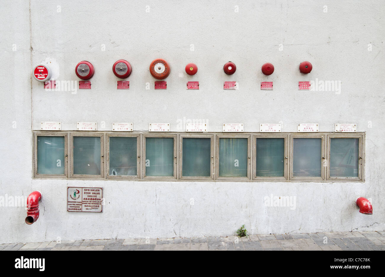 Rosso fuoco campanelli di allarme e gli idranti sul lato di un edificio in Hong Kong Foto Stock