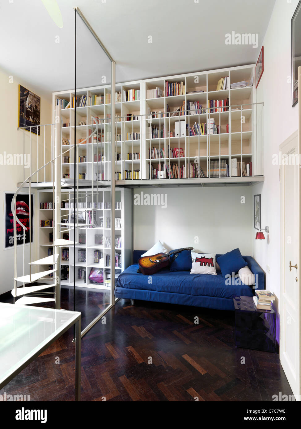 Camera moderna con pavimento in legno e la libreria sopra il letto Foto Stock