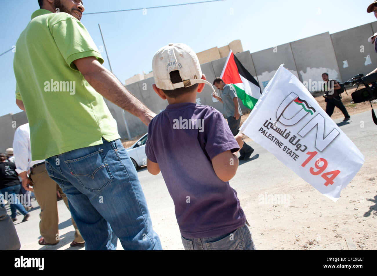 Un ragazzo porta una bandiera sostenere la costituzione dello Stato palestinese durante una manifestazione di protesta in Al-Walaja, West Bank. Foto Stock