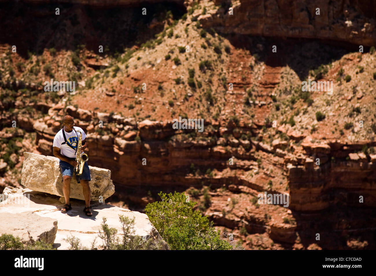 Un uomo da solo svolge il suo sassofono sul bordo del Grand Canyon South Rim Arizona USA Foto Stock