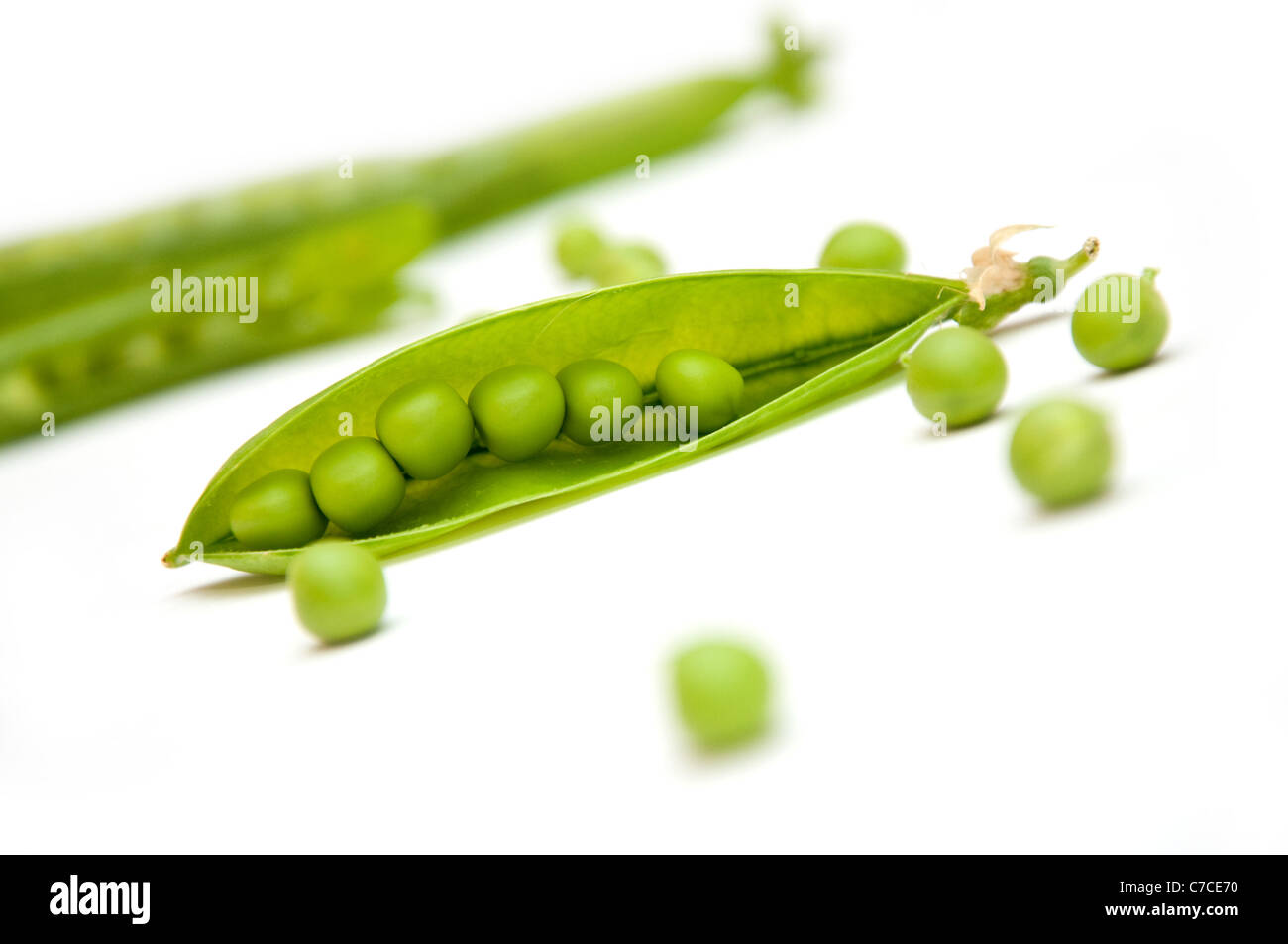 Piselli verdi baccelli su uno sfondo bianco Foto Stock