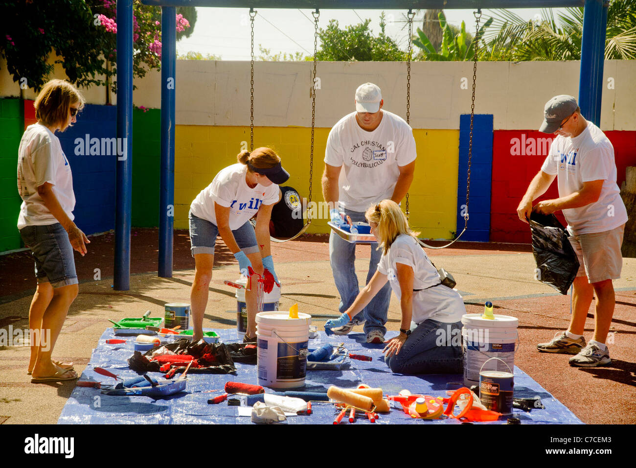 Volontari in T-shirt con logo mix vernice ad una comunità abbellimento progetto in Santa Ana CA. Foto Stock