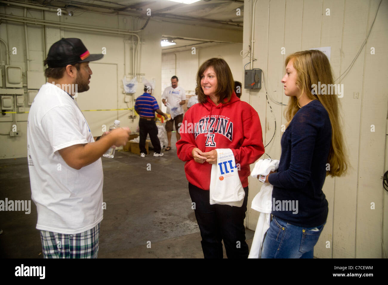 Due nuove donne volontari ottenere un incarico di lavoro in corrispondenza di una carità la distribuzione gratuita di cibo in un magazzino a Santa Ana CA. Foto Stock