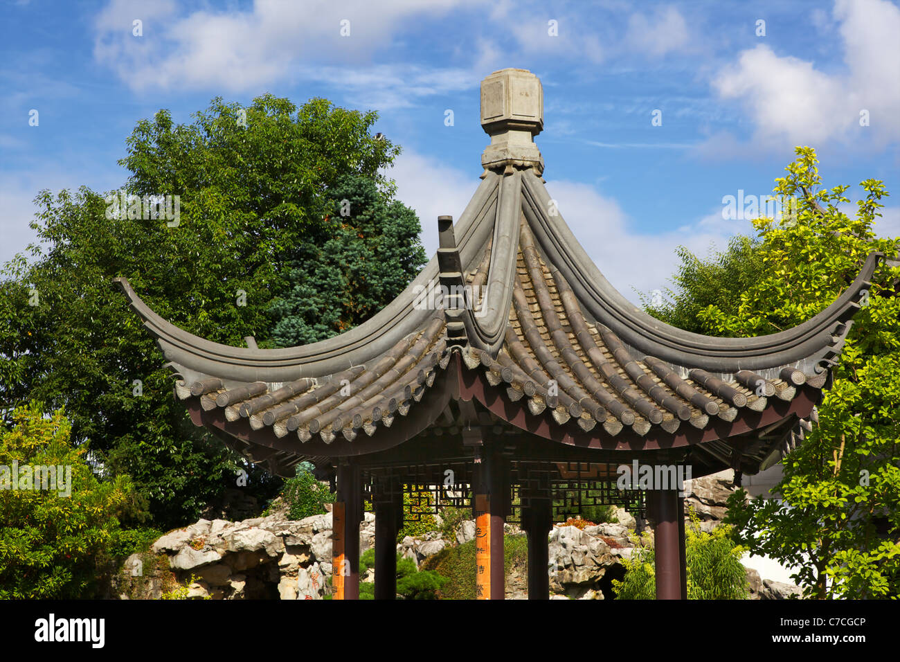 Piccola pagoda cinese tetto contro il cielo blu e verde sfondo ad albero Foto Stock