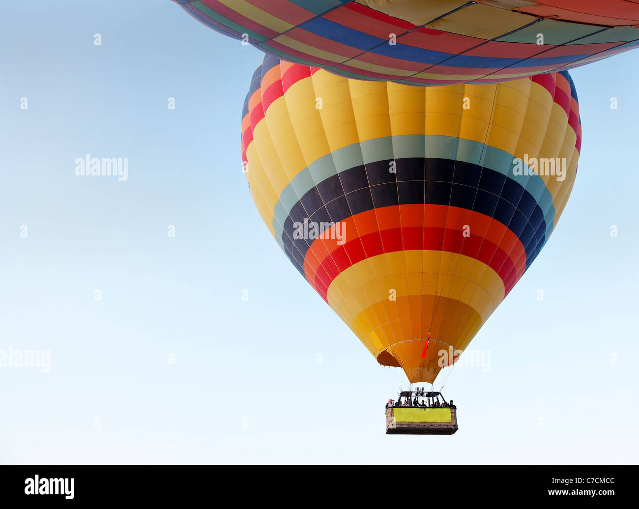 Concetto di paesaggio di due colorato i palloni ad aria calda in una chiara luce blu cielo con un paniere di passeggeri Foto Stock
