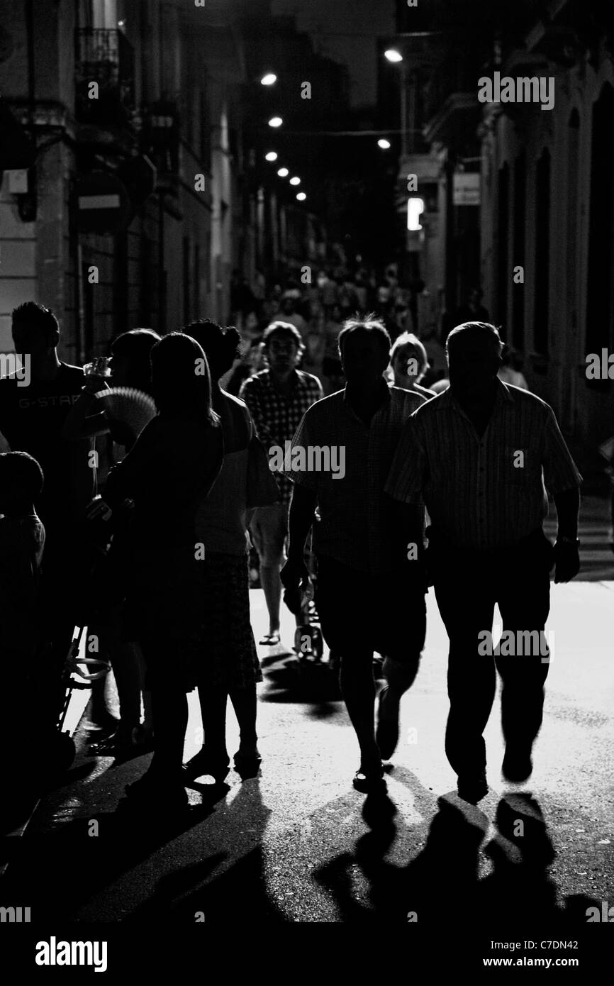 La gente a piedi attraverso Gracia, Barcellona di notte Foto Stock