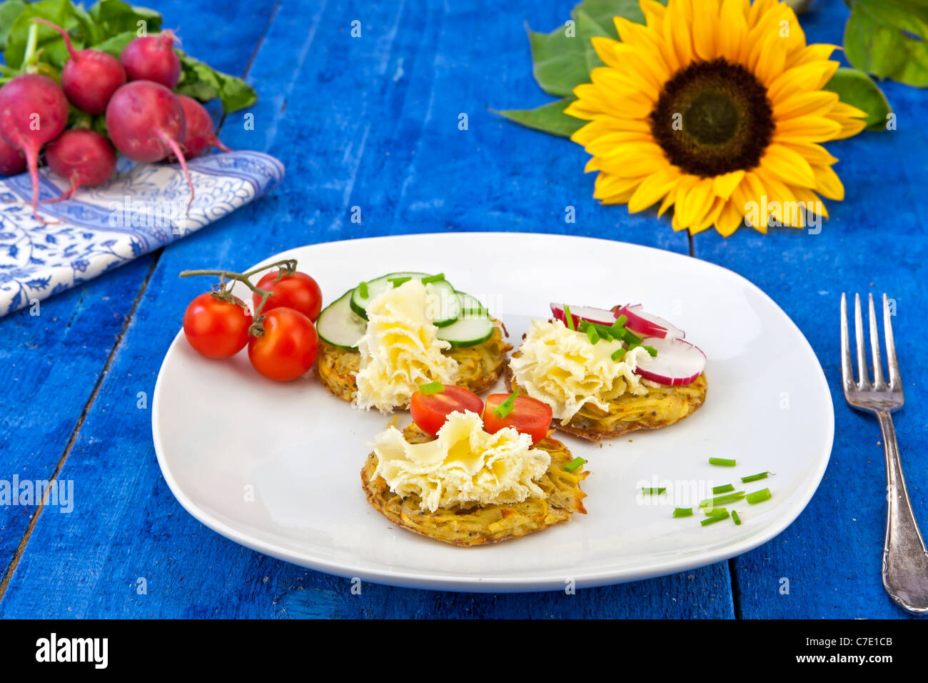 Patate dal forno, servito con il Tête de Moine Formaggi e guarnita con pomodori, cetrioli e ravanelli Foto Stock