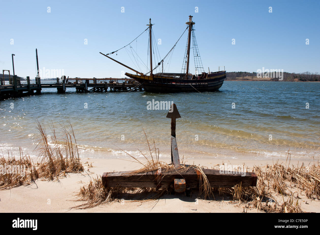 Elemento di ancoraggio su una spiaggia con nave ormeggiata in background Foto Stock