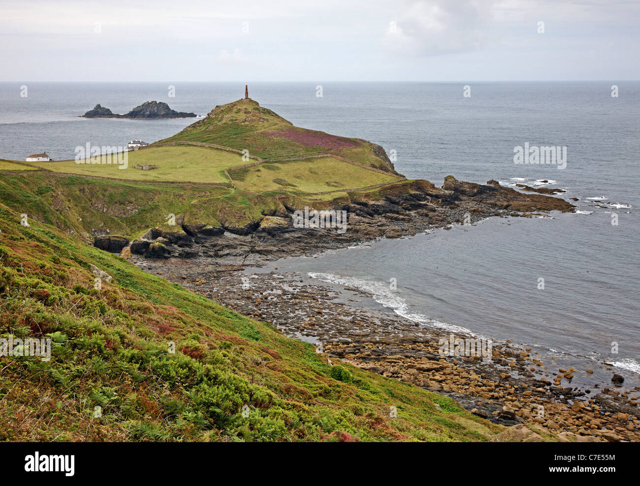 Cape Cornwall sormontato dal suo memorial camino vicino a St solo in Cornovaglia con la Brisons oltre Foto Stock