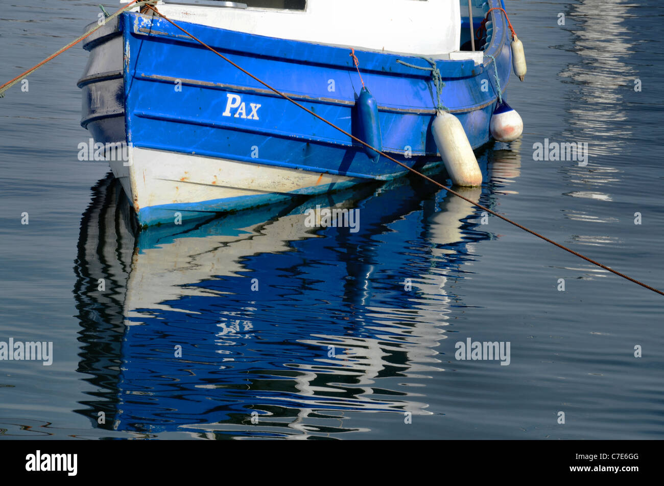Una piccola barca con riflessioni, ormeggiata nel porto di Newhaven, Edimburgo, Scozia, Regno Unito. Foto Stock