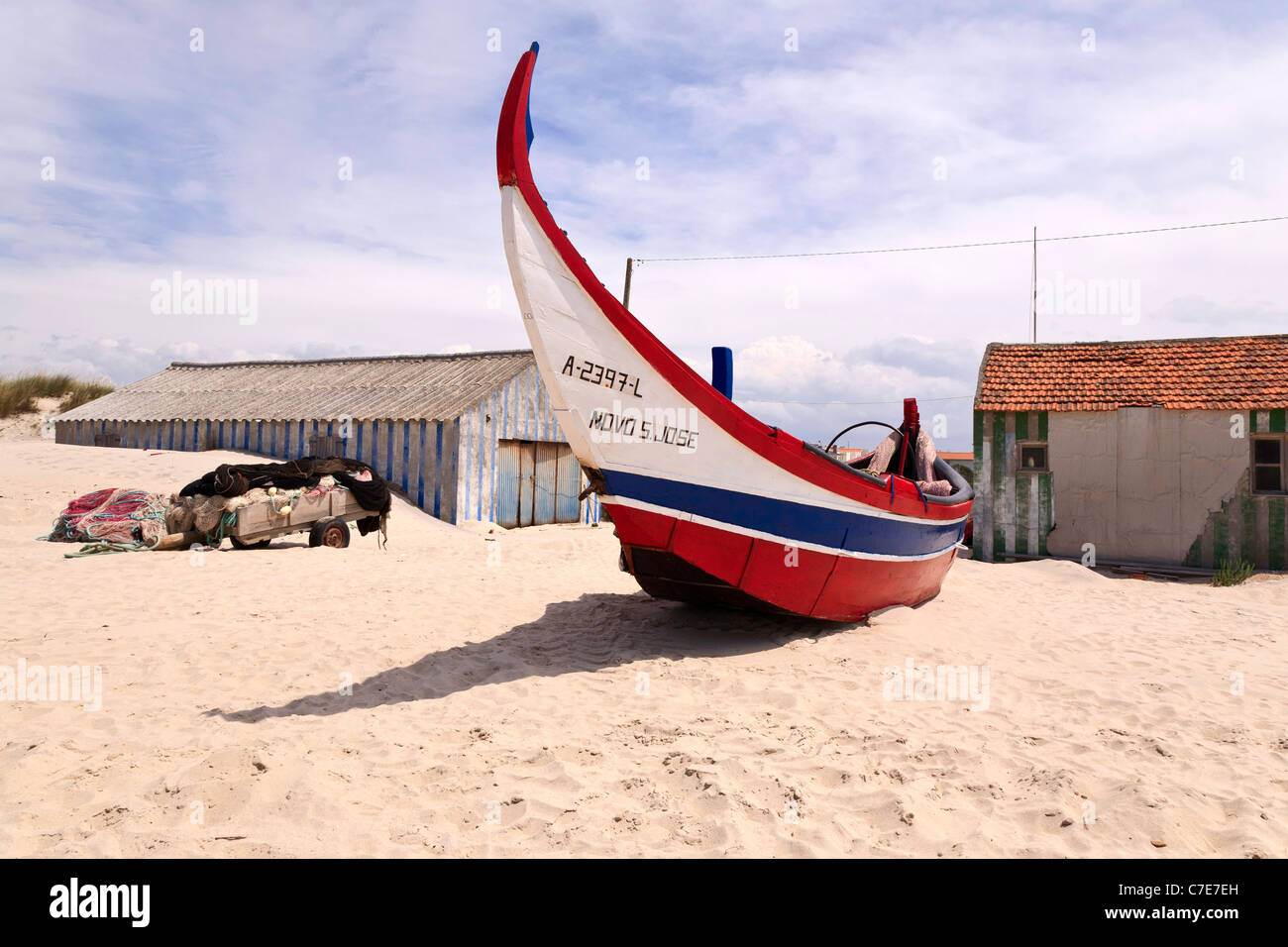 Tradizionale in rosso, bianco e blu in legno barca da pesca. Praia de Mira - costa ovest del Portogallo Foto Stock