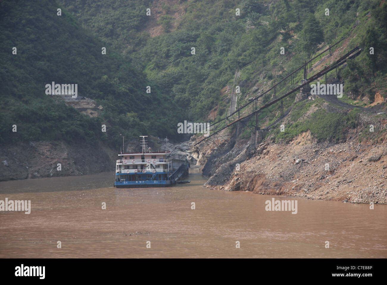 Fiume freighter essendo caricato con carbone in Wu Gorge, Fiume Yangtze, Cina Foto Stock