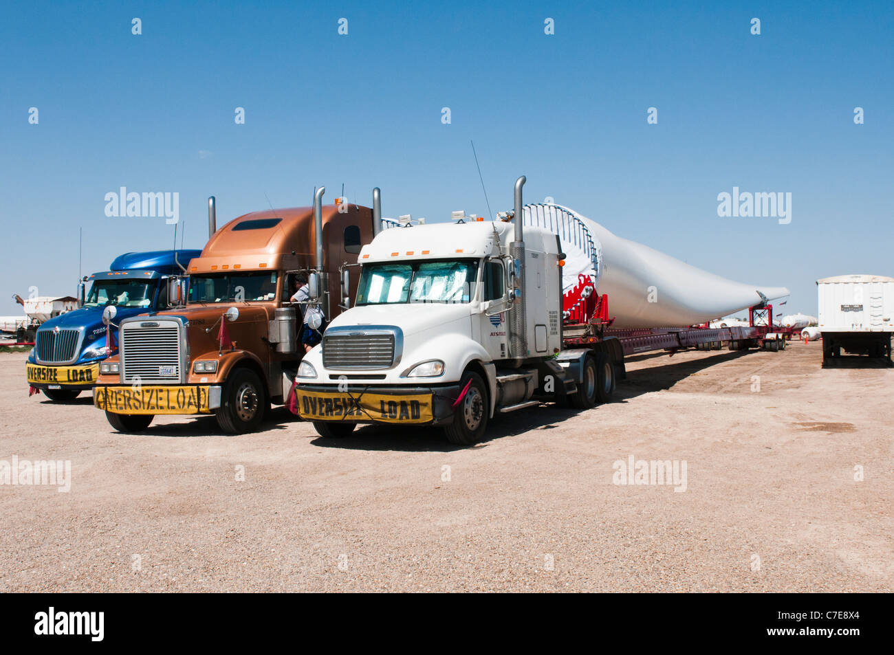 Le pale del rotore per nuove turbine eoliche sono trasportati da autocarri e rimorchi speciali per il parco eolico sito in costruzione. Foto Stock