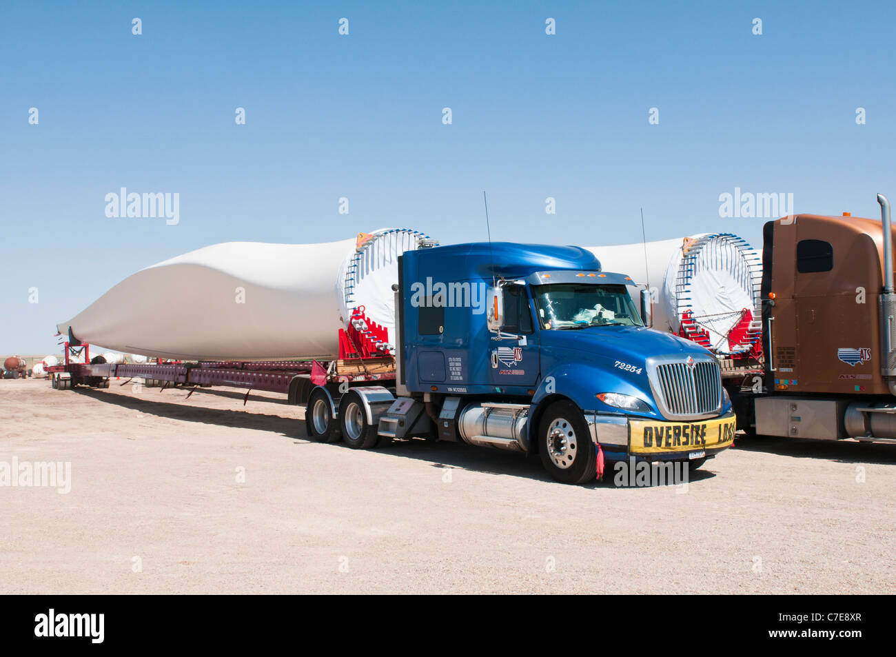 Le pale del rotore per nuove turbine eoliche sono trasportati da autocarri e rimorchi speciali per il parco eolico sito in costruzione. Foto Stock
