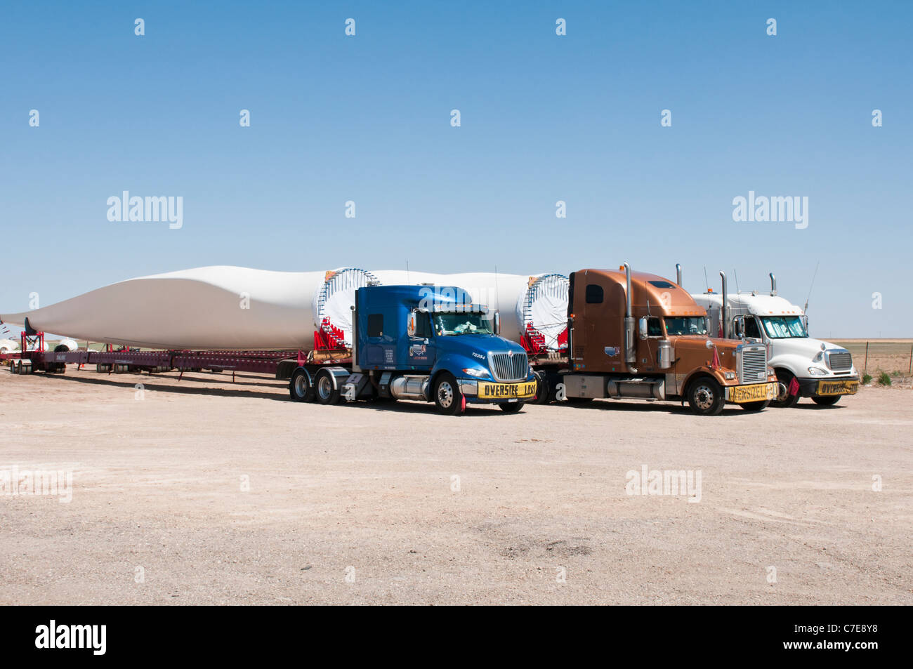 Le pale del rotore per nuove turbine eoliche sono trasportati da autocarri e rimorchi speciali per il parco eolico sito in costruzione. Foto Stock