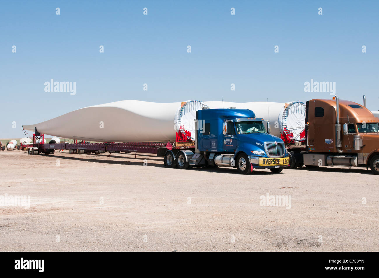 Le pale del rotore per nuove turbine eoliche sono trasportati da autocarri e rimorchi speciali per il parco eolico sito in costruzione. Foto Stock