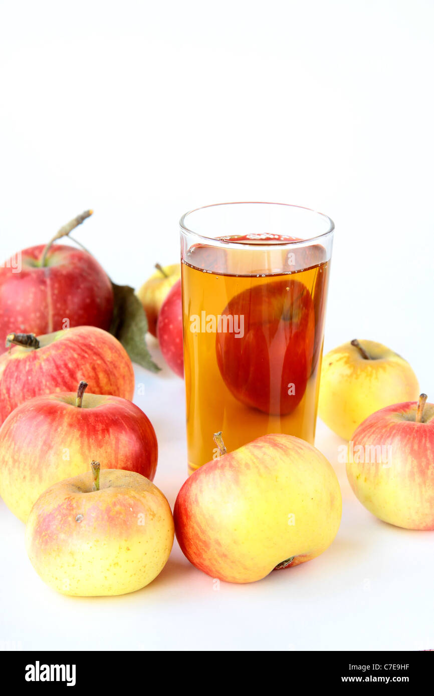 Il succo di mela in vetro e mele fresche su sfondo bianco Foto Stock