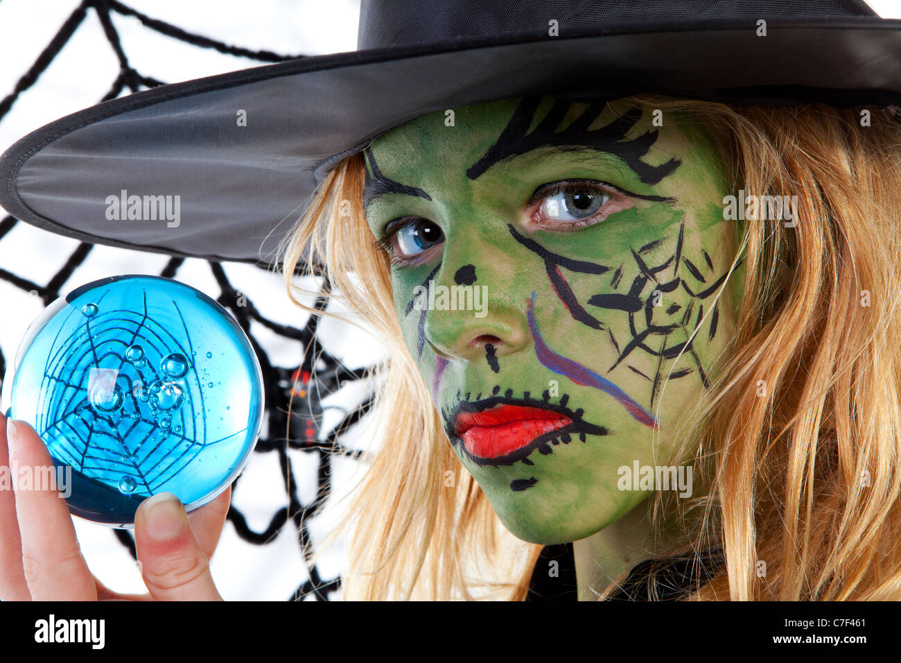 Ritratto di green Halloween Ragazza strega azienda Big Blue Marble in primo piano Foto Stock