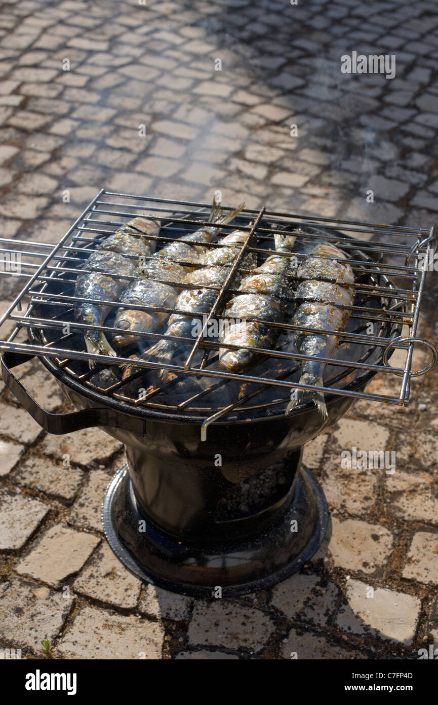 Il Portogallo, Algarve, un rustico di sardine grigliate su una strada acciottolata Foto Stock