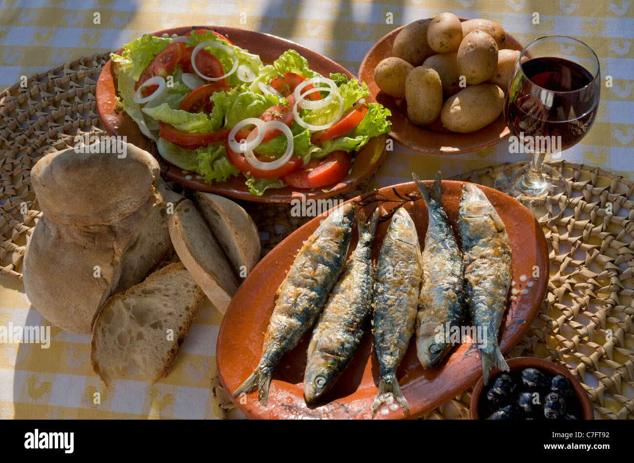 Il Portogallo, Algarve, sardine grigliate, insalata e un bicchiere di vino Foto Stock