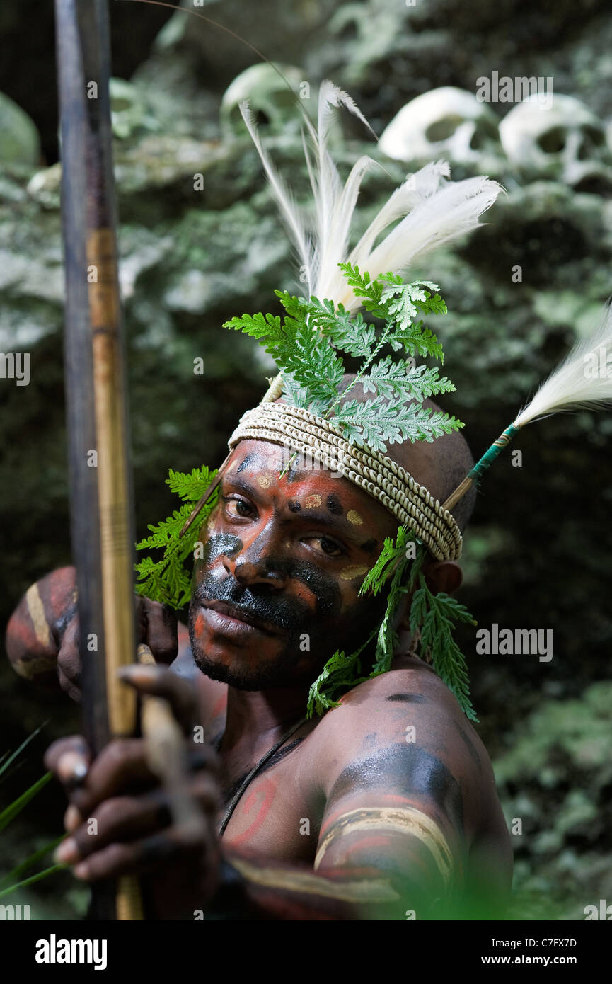 Il guerriero di una tribù di Papua di Yafi in abiti tradizionali, ornamenti e colorazione. Foto Stock