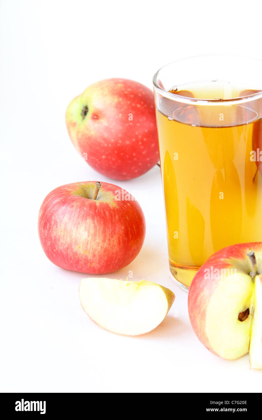 Il succo di mela in vetro e mele fresche su sfondo bianco Foto Stock