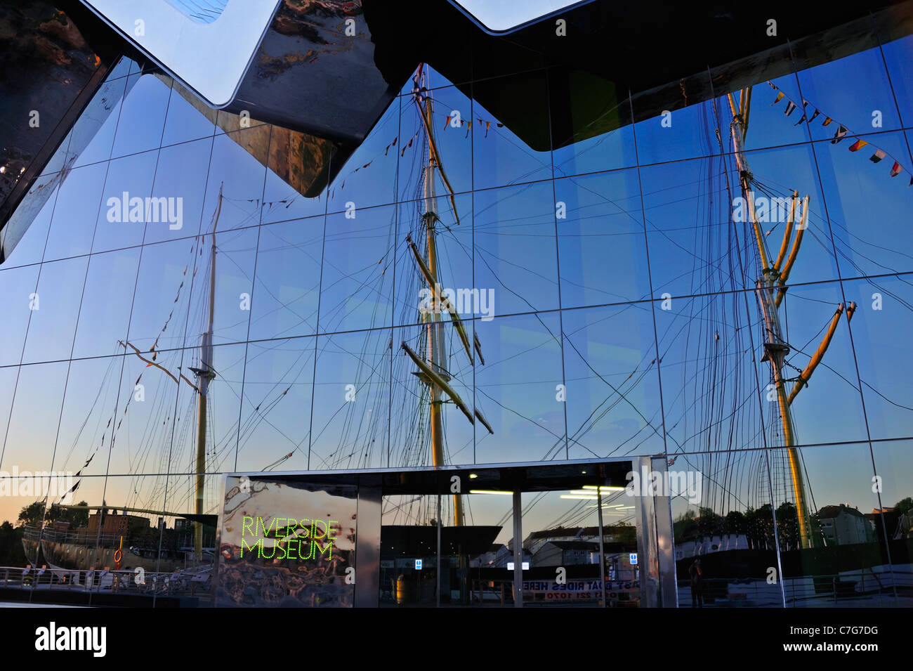 La facciata del Riverside Museum di Glasgow con il brigantino a tre alberi, il Glenlee riflessa nel vetro Foto Stock