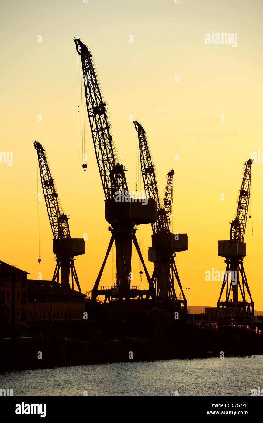 Gru di un cantiere navale di Glasgow stagliano contro il cielo di alba/tramonto (potrebbe essere sia). Spazio per il testo nel cielo. Foto Stock