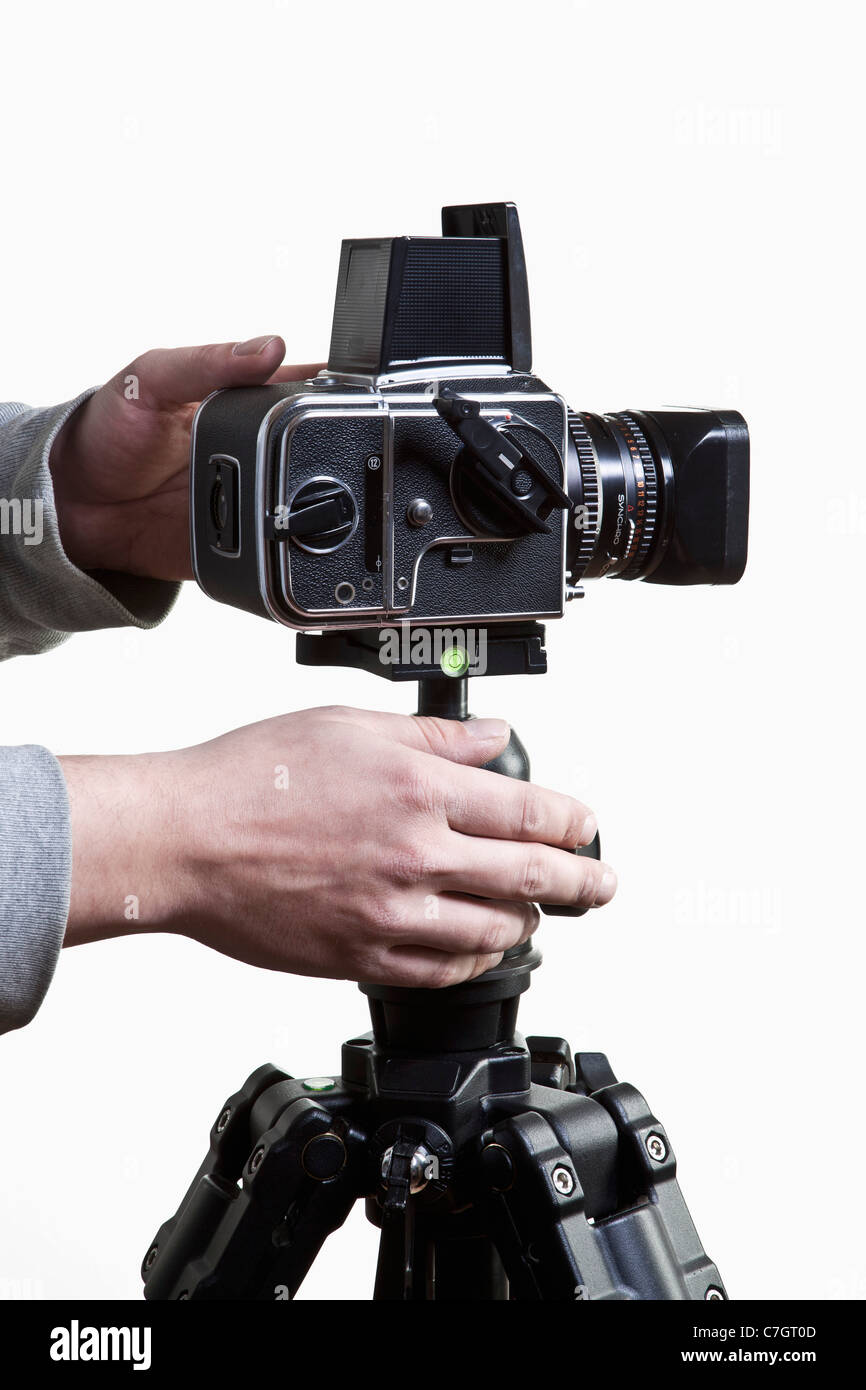 Un fotografo la regolazione di una fotocamera di medio formato su un treppiede, close-up delle mani Foto Stock