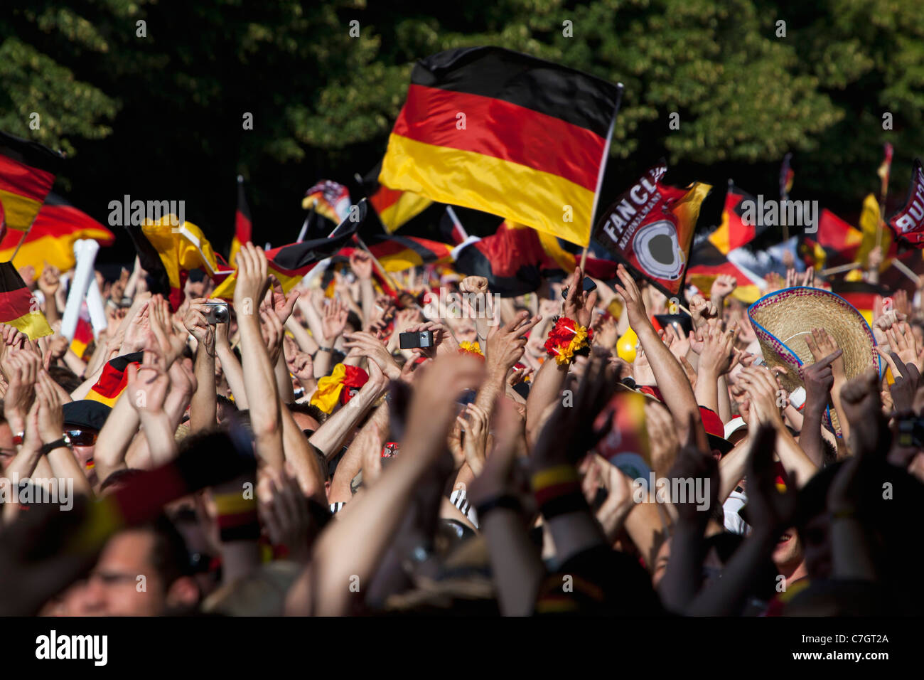 Dettaglio delle persone in una folla sventolando bandiere tedesco Foto Stock