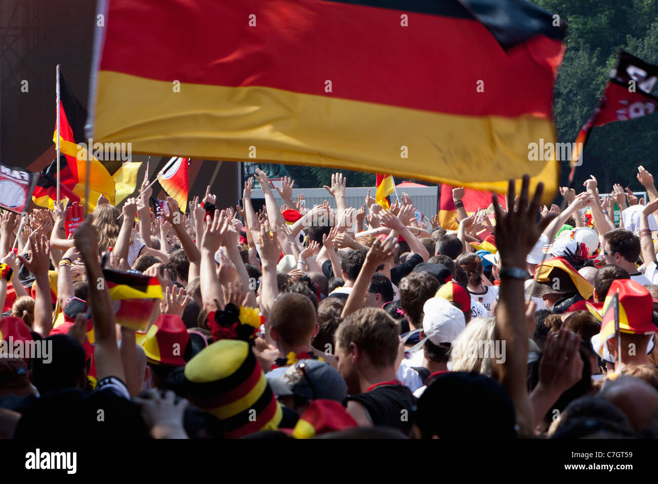 Dettaglio delle persone in una folla che acclamava e sventolando bandiere tedesco Foto Stock