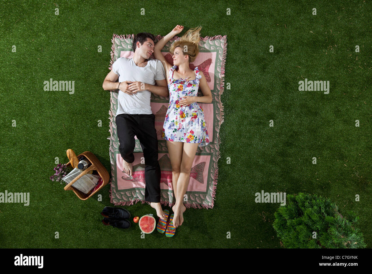 Un giovane che giace su una coperta in un parco guardando ogni altro romanticamente, vista aerea Foto Stock