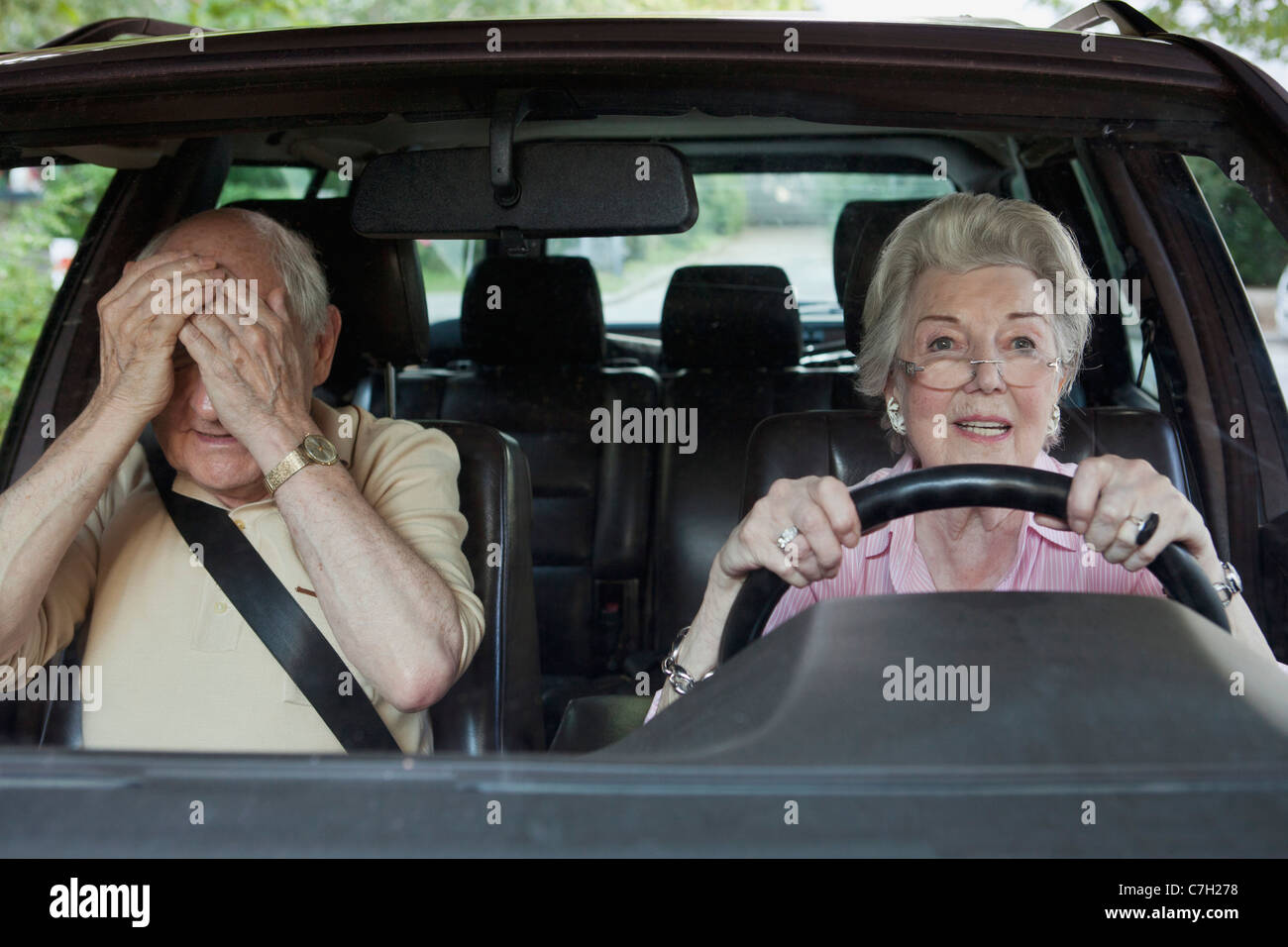 La donna ha problemi di guida mentre l'uomo nel sedile del passeggero scompare Foto Stock