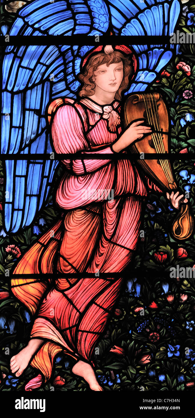 Una finestra di vetro colorato, da Edward Burne-Jones, raffigurante un angelo alato di riproduzione di un liuto Foto Stock