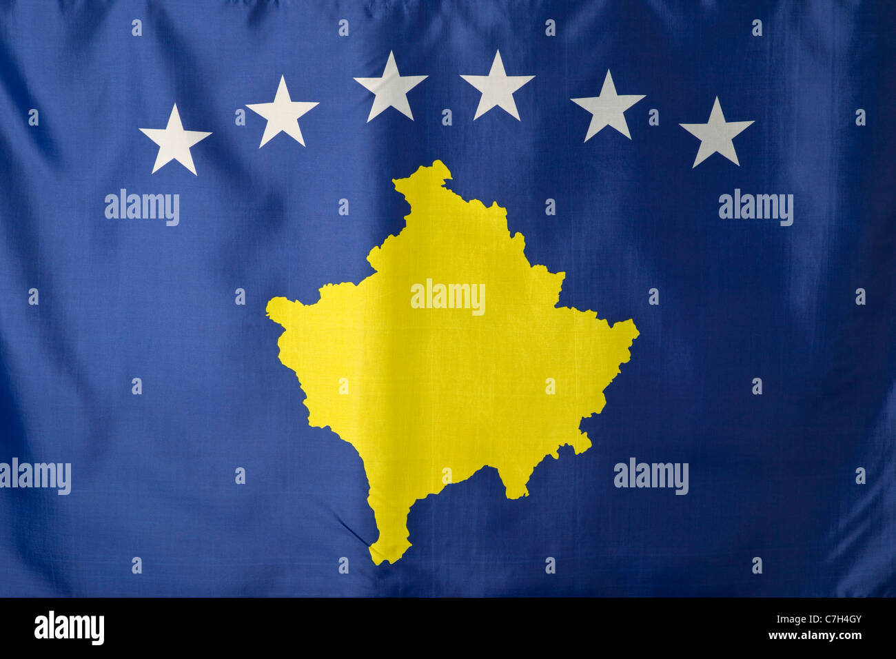 Il Kosovo, bandiera blu con un oro oggetto mappa del Kosovo sotto un arco di sei stelle bianche Foto Stock