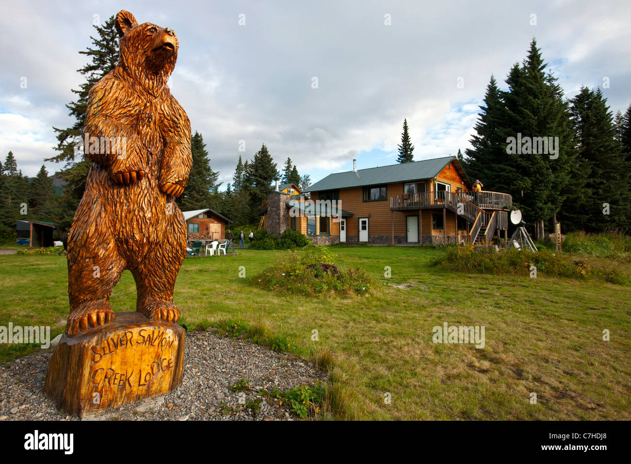 Vista del salmone argento Creek Lodge di legno di orso grizzly statua, il Parco Nazionale del Lago Clark, Alaska, Stati Uniti d'America Foto Stock