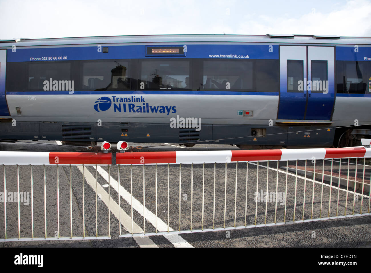 Treno nir livello passando attraversando le barriere verso il basso chiuso castlerock stazione ferroviaria Irlanda del nord italia azione sfocatura del movimento Foto Stock