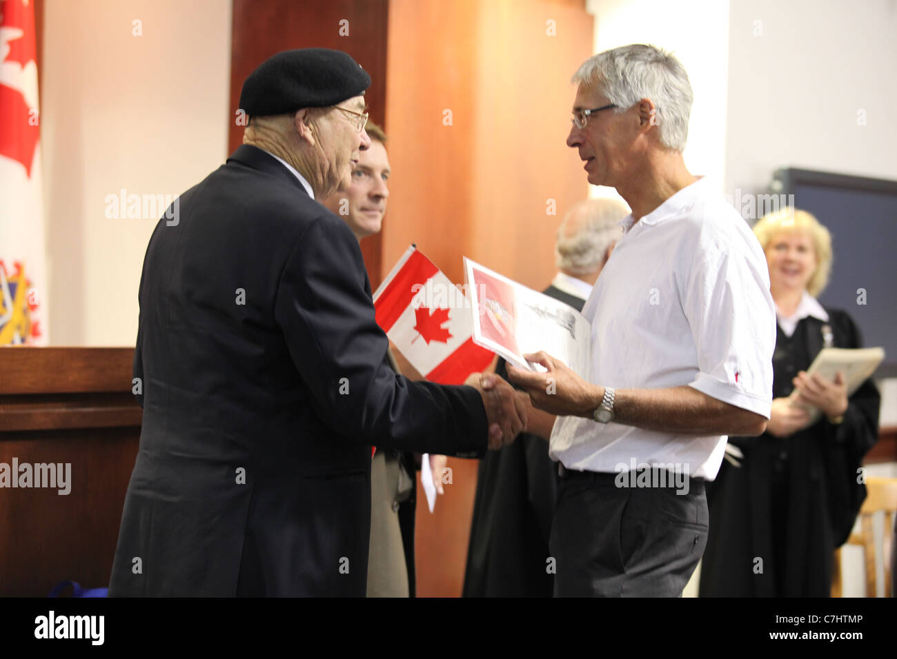 La cittadinanza di giudice e sindaco della città si stringono la mano nuovi cittadini canadesi in una cerimonia di cittadinanza di Kitchener, Ontario Foto Stock