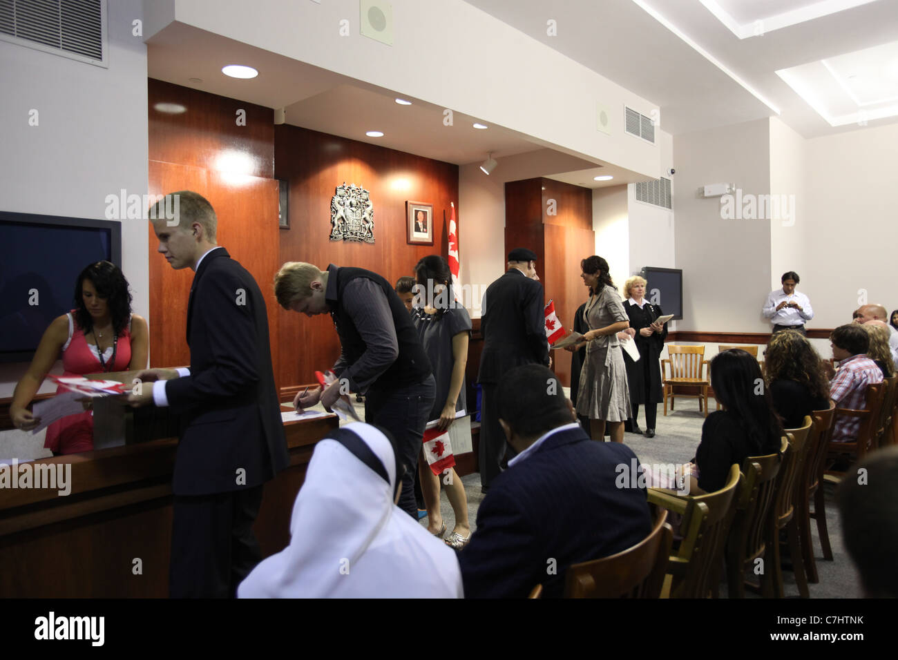 Nuovi immigrati canadese firma di documenti che accetta la cittadinanza canadese in una cerimonia di cittadinanza in Ontario Foto Stock