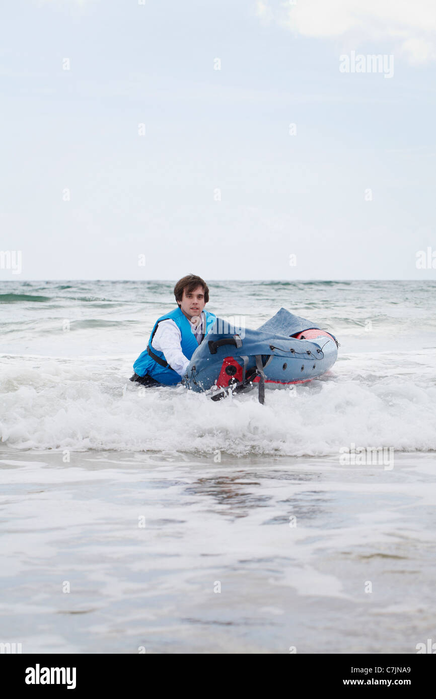 Imprenditore spingendo la canoa in ocean Foto Stock